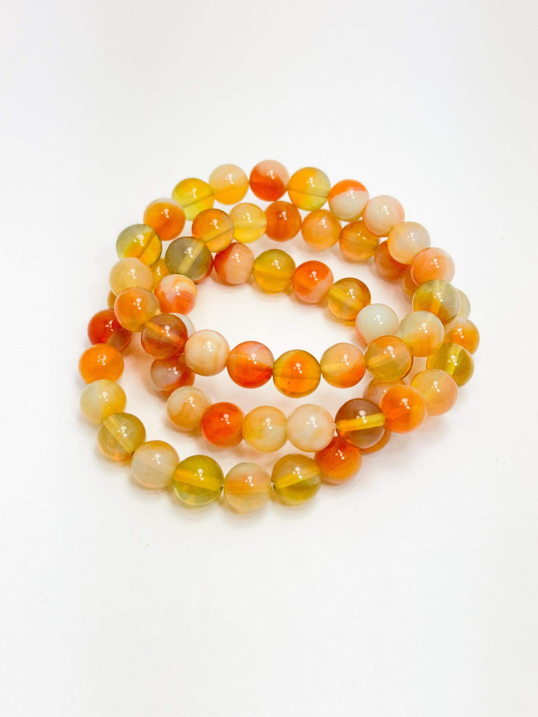 citrus colored beaded bracelets on white background