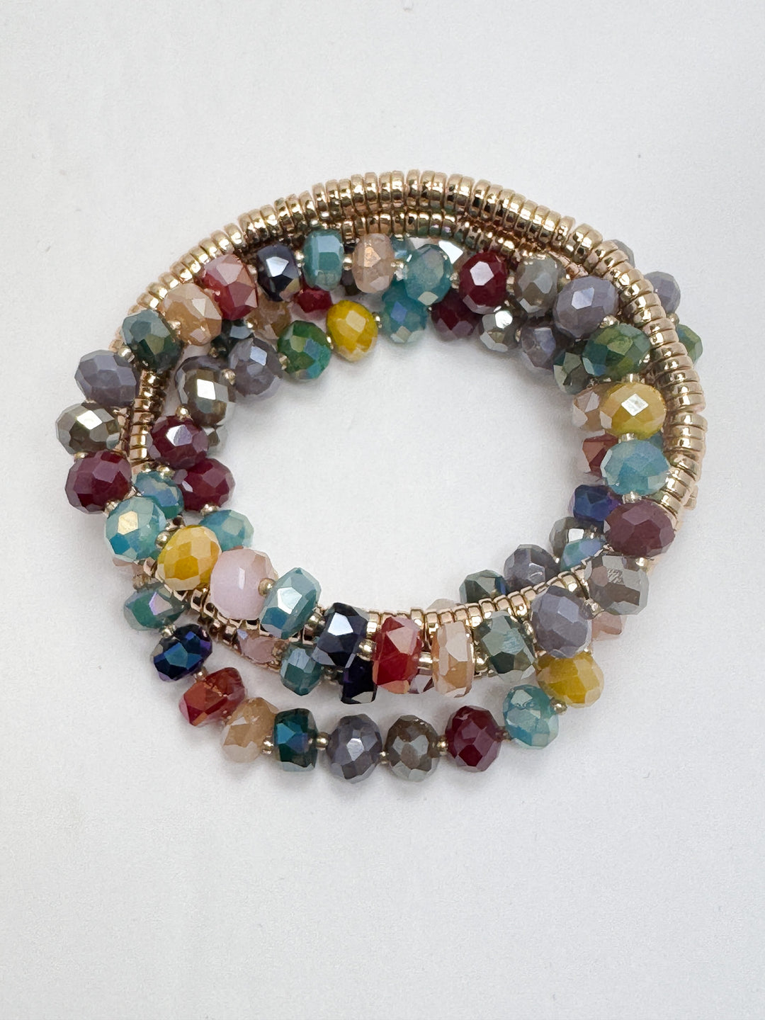 A stack of beaded bracelets featuring a variety of colors including blue, green, gold, and red.