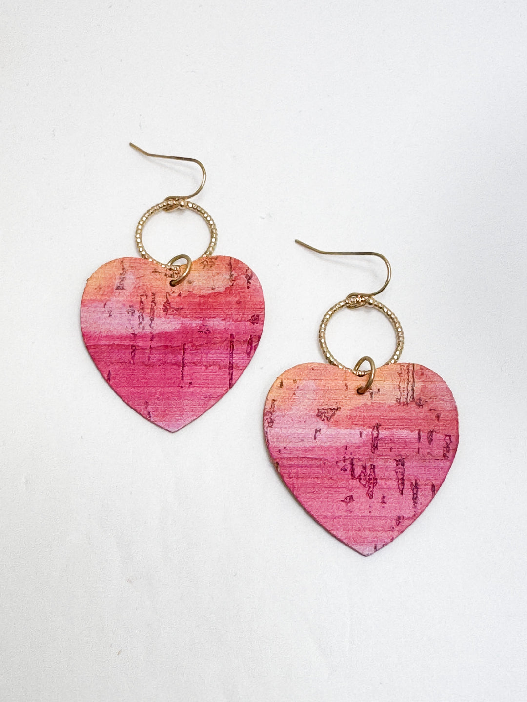 two pink ombre heart earrings on white background