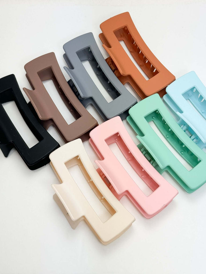 various colors of rectangular hair clips on white background