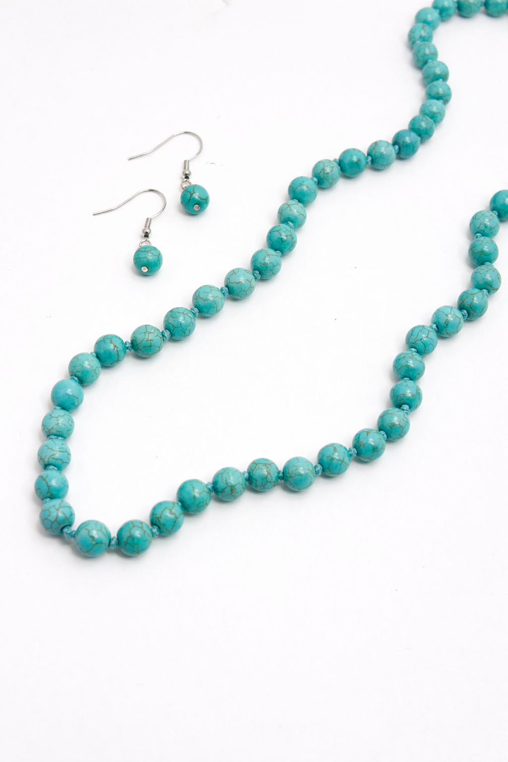 Turquoise beaded necklace and earrings on a white background