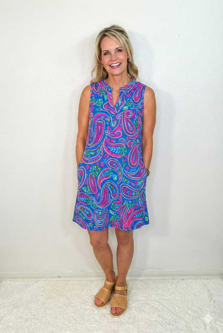Woman wearing a colorful paisley dress against a white background