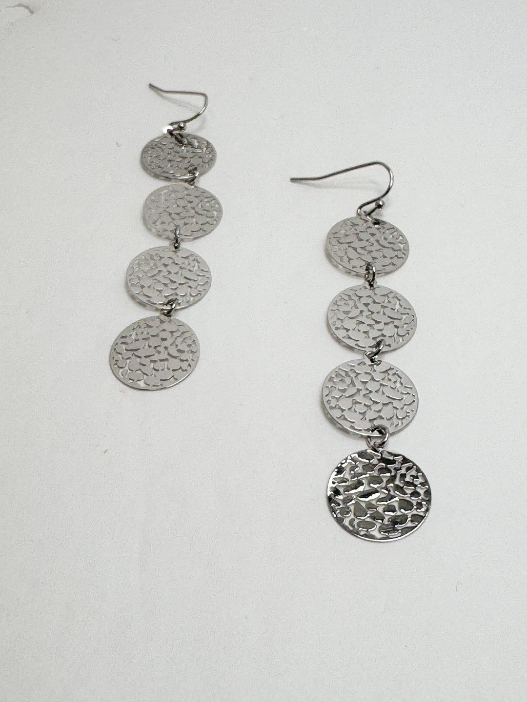 A pair of silver cascading filigree earrings with multiple circular pendants attached to each other in a vertical line, dangling from ear wires.
