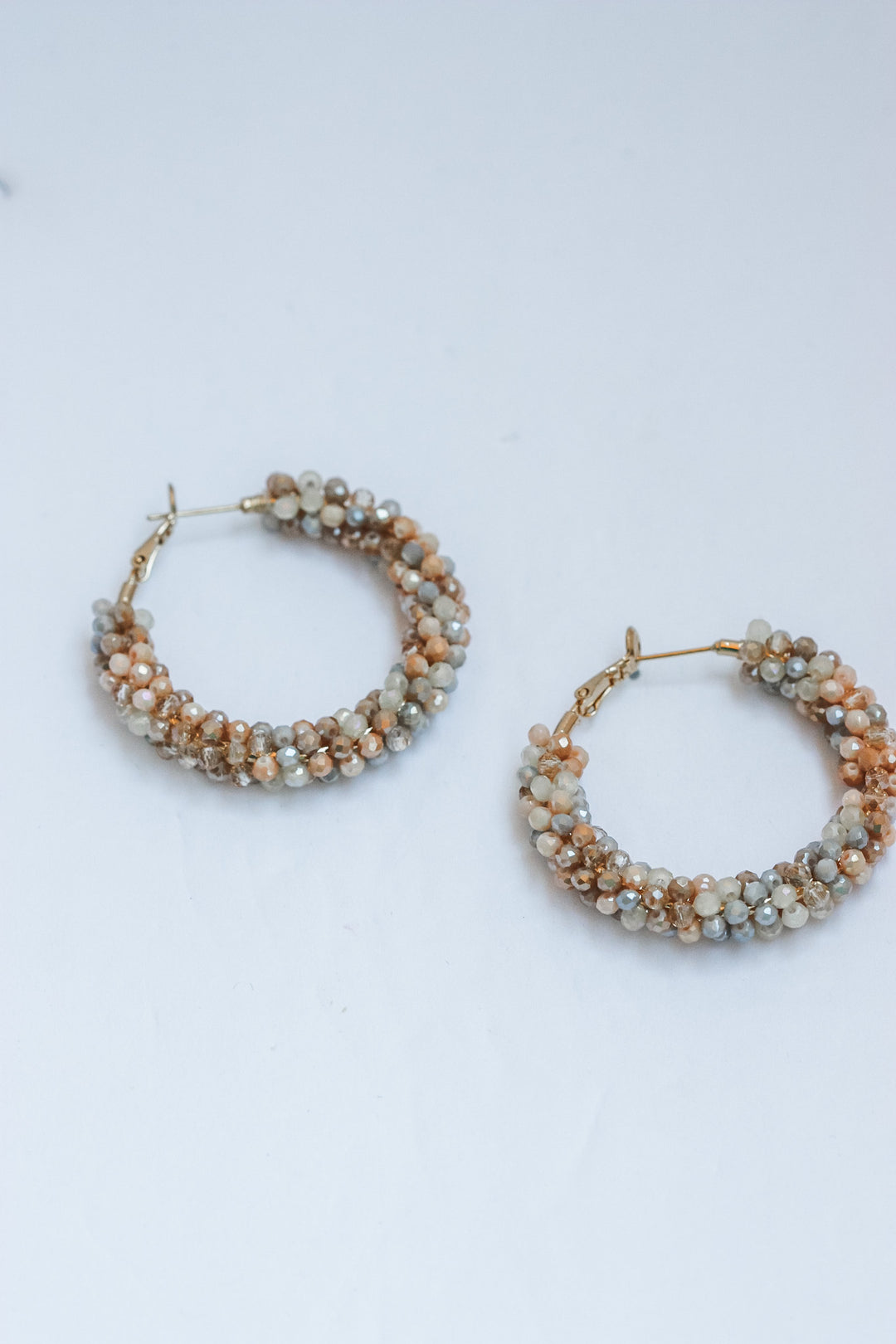 Pair of beaded hoop earrings on a light background