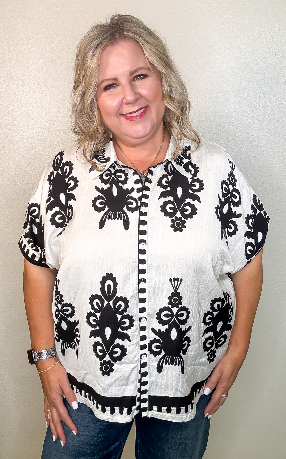 Woman wearing a white shirt with black floral patterns