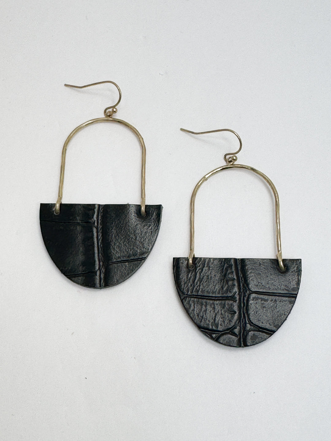 A pair of black leather drop earrings with silver hoops.