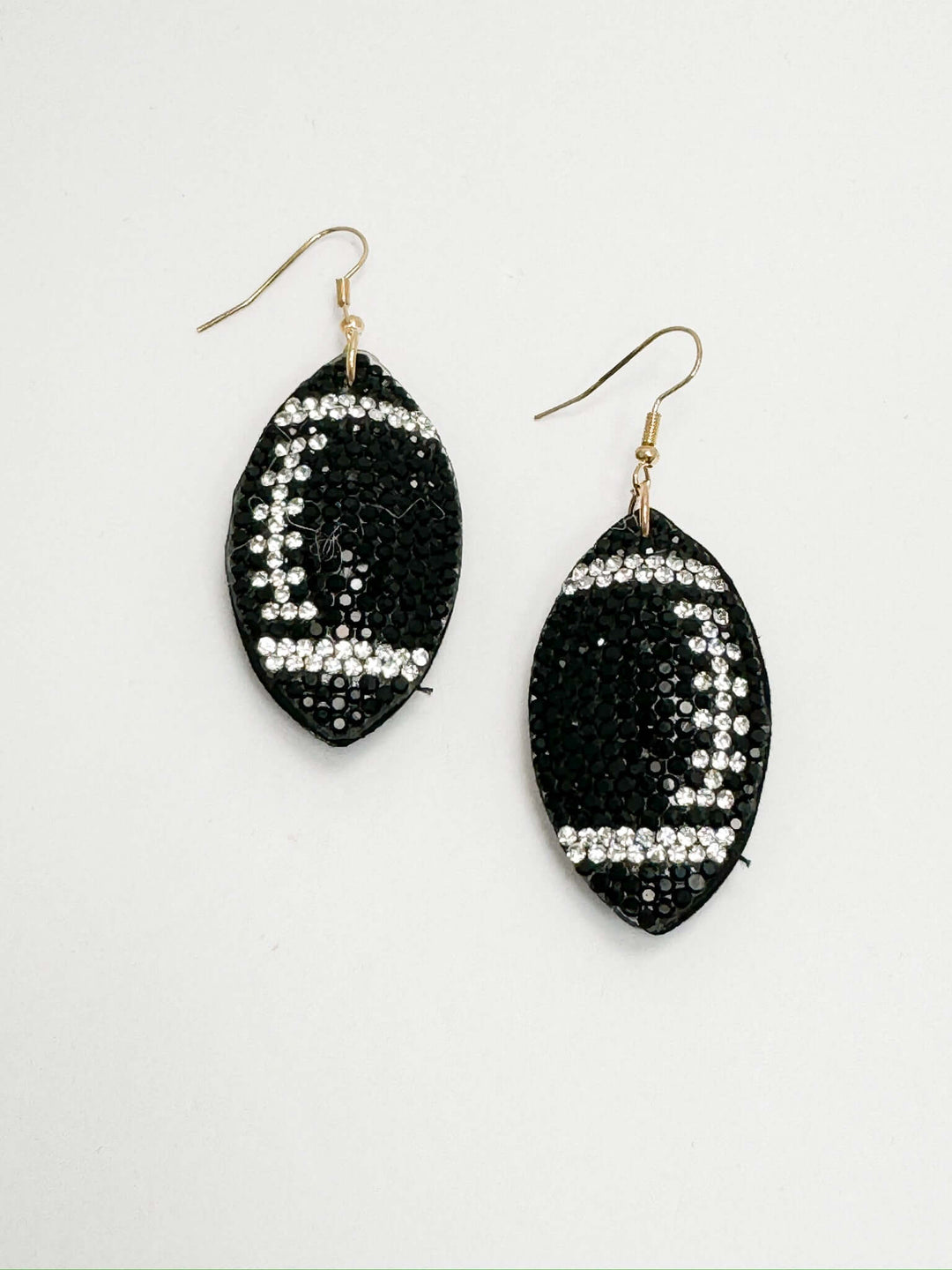 black and white rhinestone football earrings on white background
