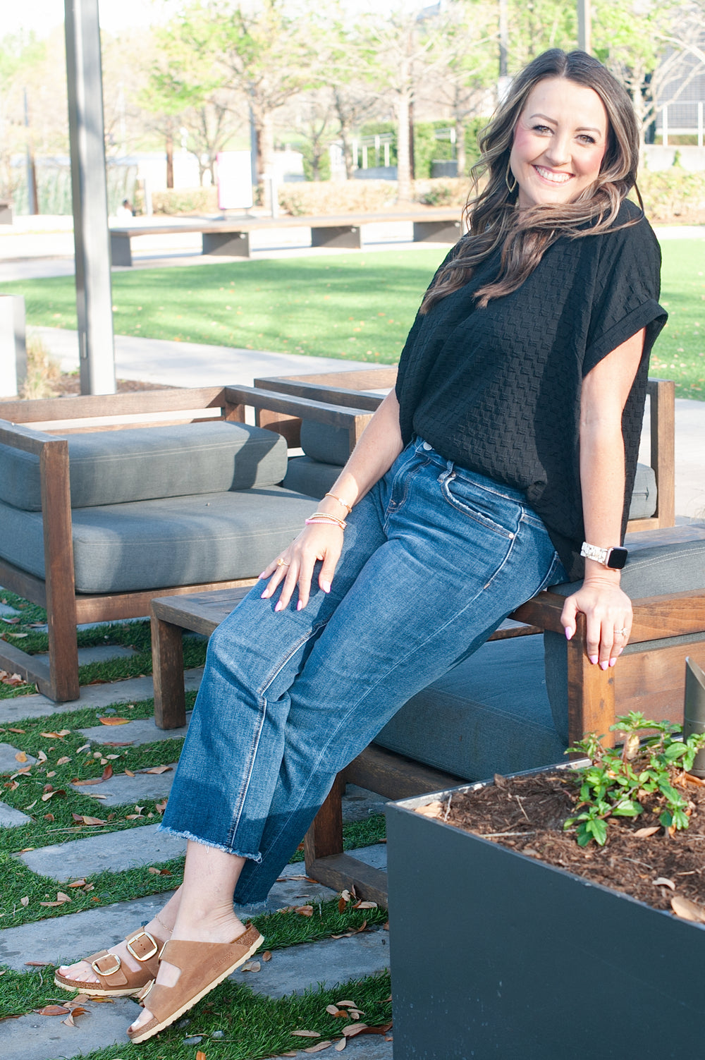model leaning on chair wearing black top