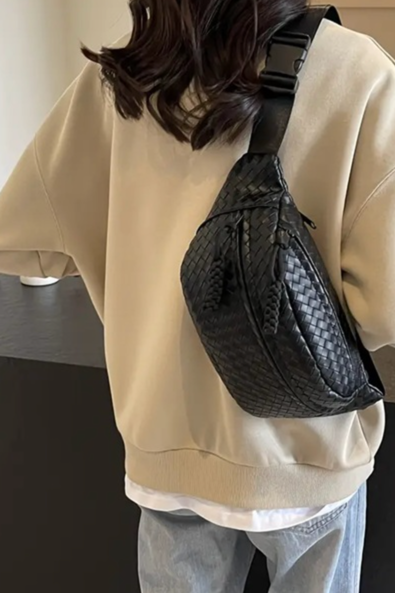 back view of woman wearing a black woven crossbody