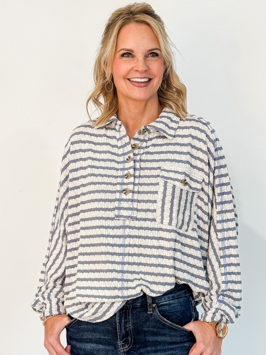 Woman wearing a striped shirt with a plain background