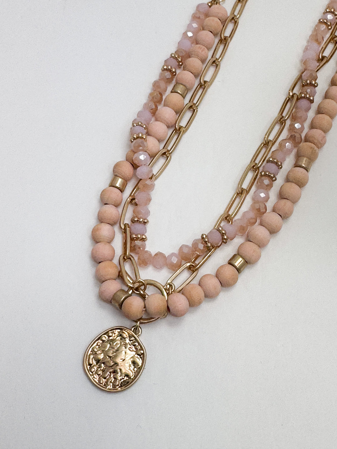 beaded necklace with gold link chain and round coin pendant