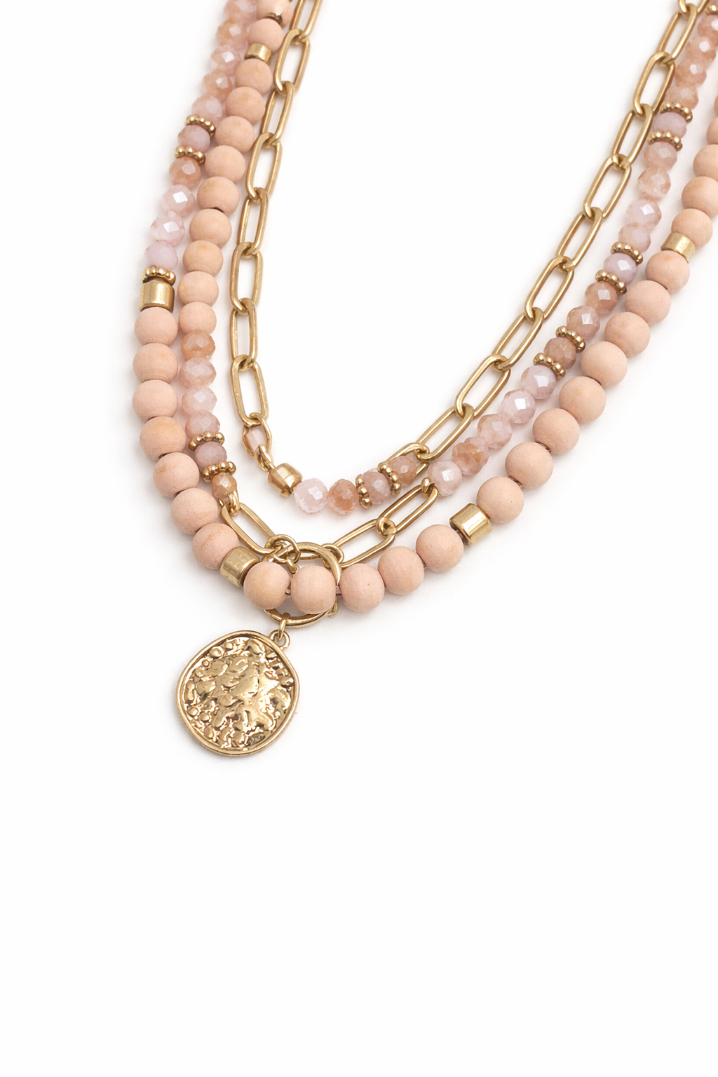 Stack of beaded necklaces with gold chains and a pendant on a white background