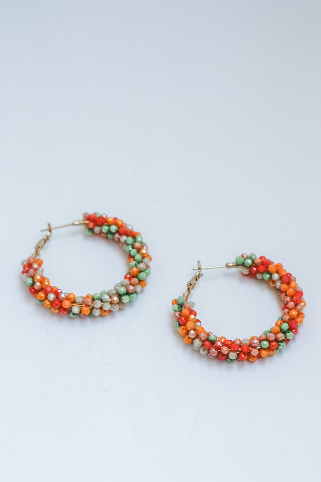 Pair of beaded hoop earrings on a light gray background