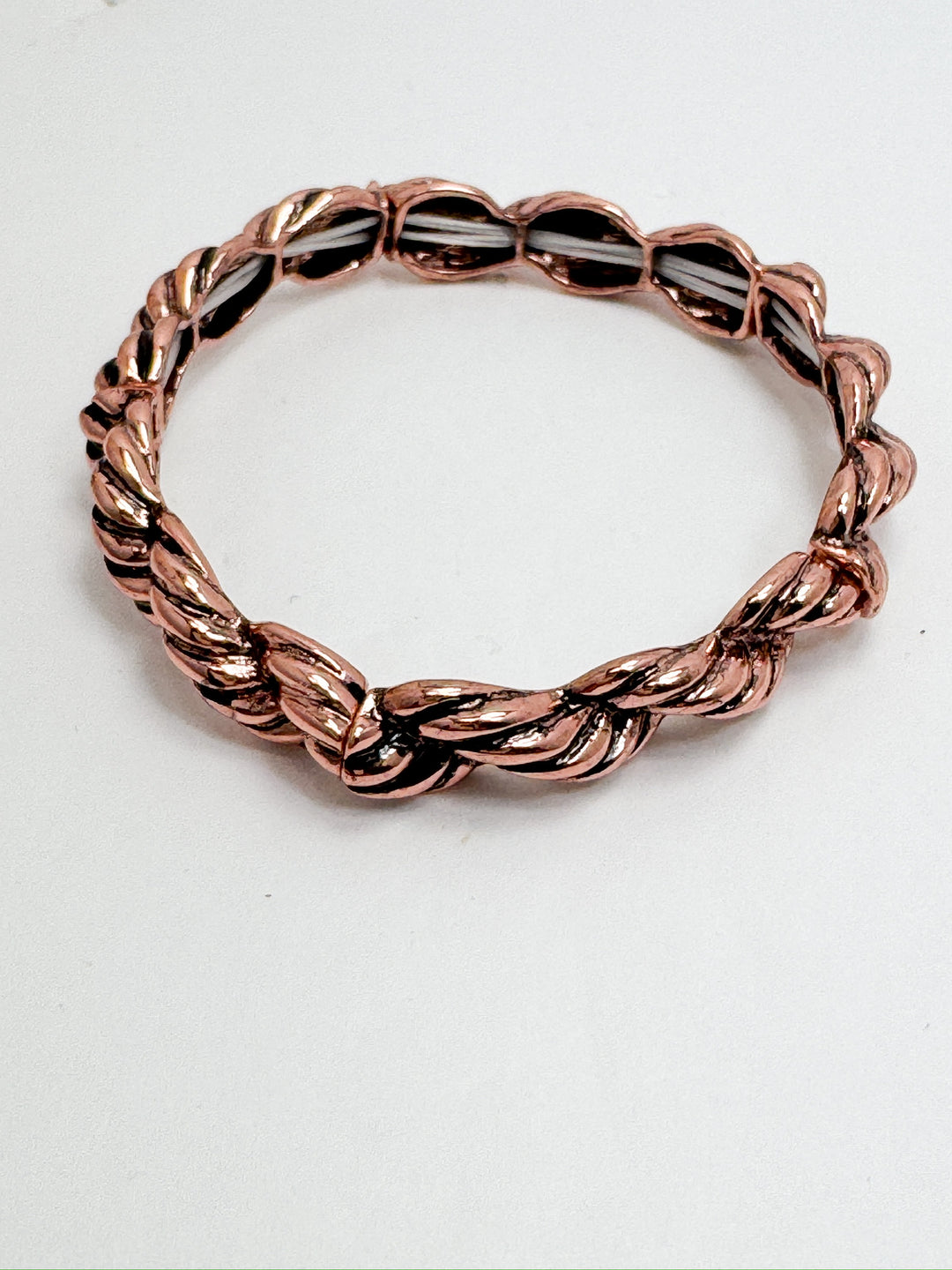 A stretchy bracelet with copper rope details against a white background