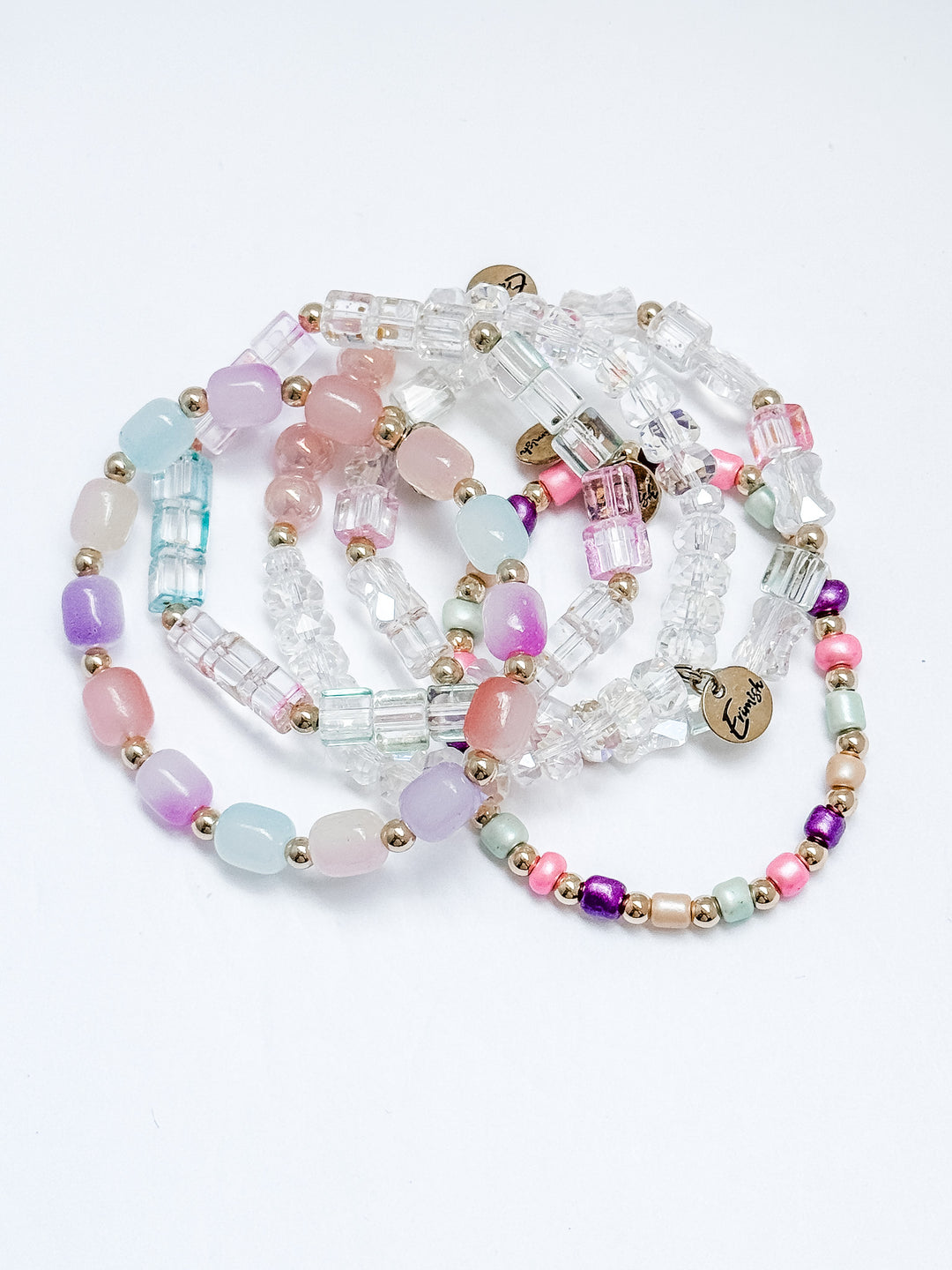Stack of colorful beaded bracelets on a white background