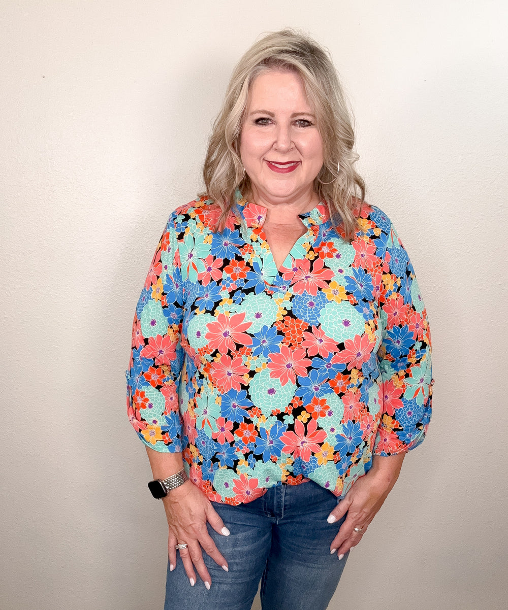 woman wearing floral top against white wall