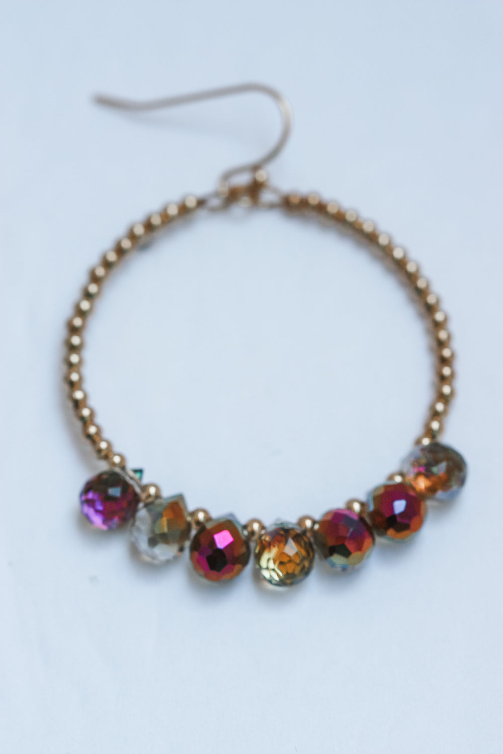 Multicolored beaded earring on a light gray background