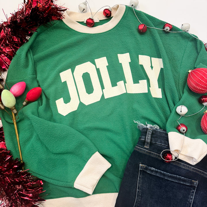 Green sweater with 'JOLLY' text surrounded by Christmas decorations