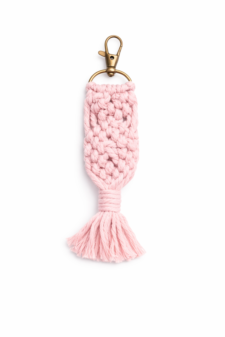 Pink knitted keychain with gold clasp on a white background