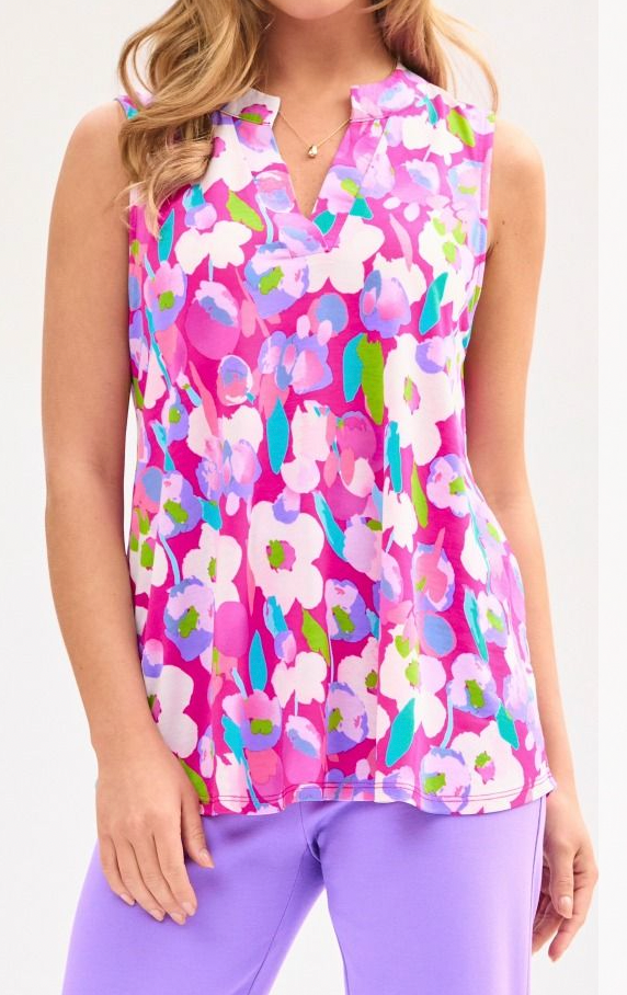 Woman wearing a sleeveless top with a colorful floral pattern and purple pants.