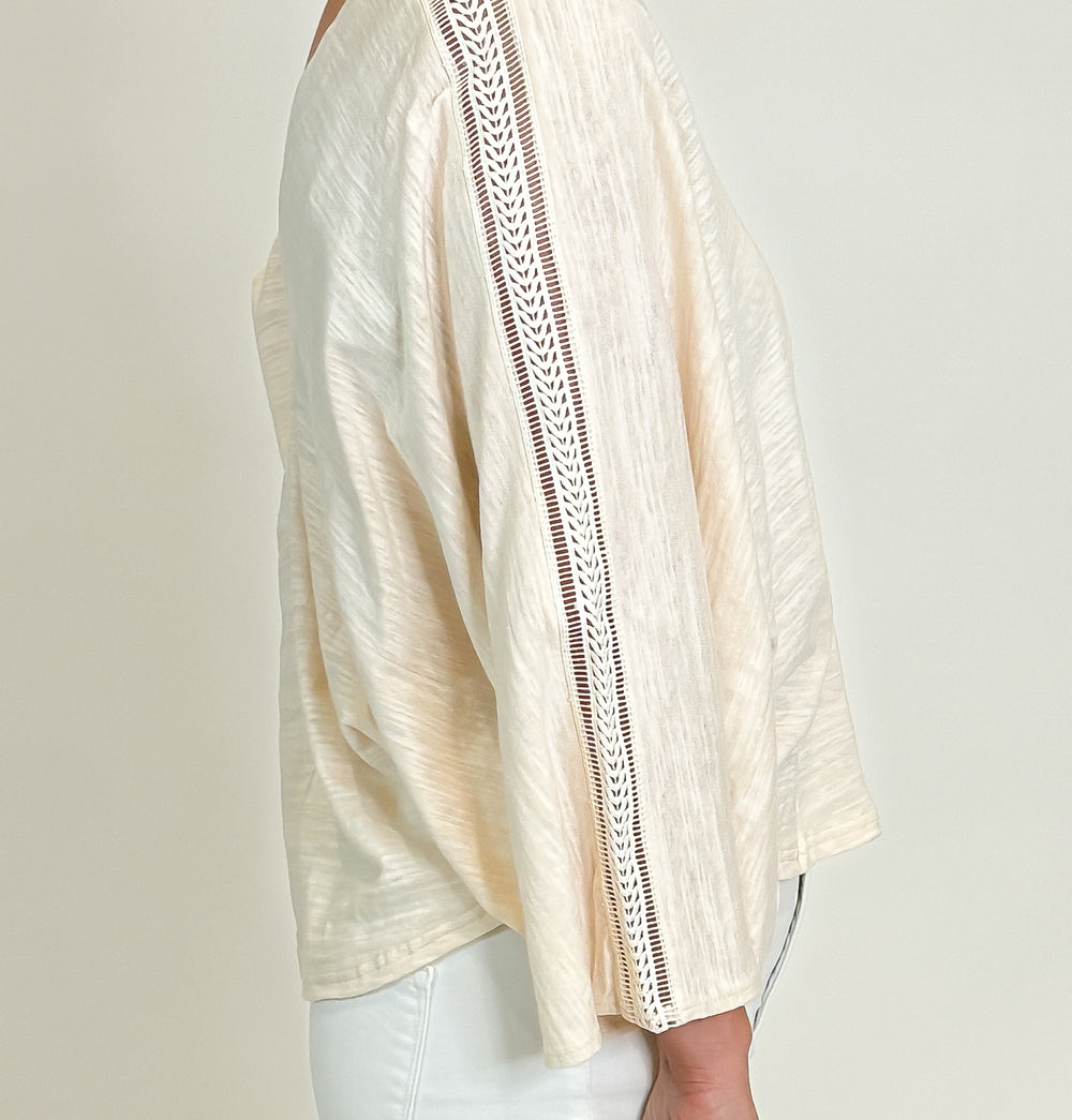 model wearing an ivory top side view with lace down sleeve