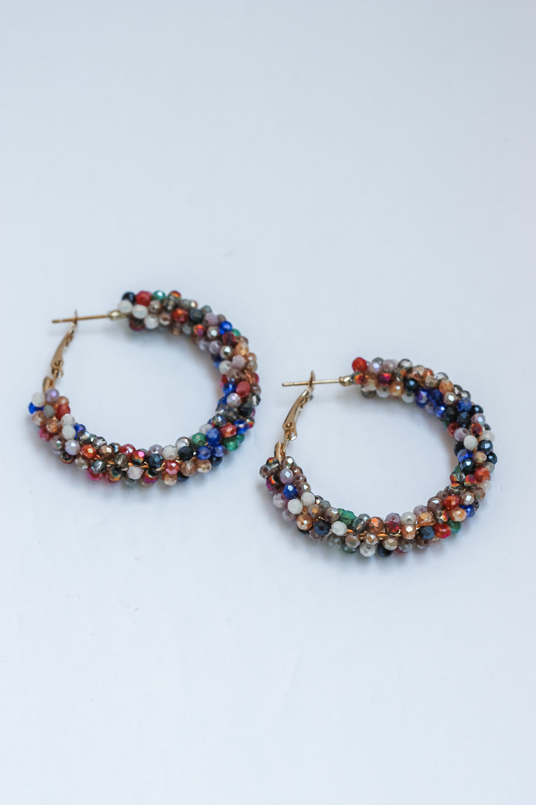 Pair of beaded hoop earrings on a light gray background