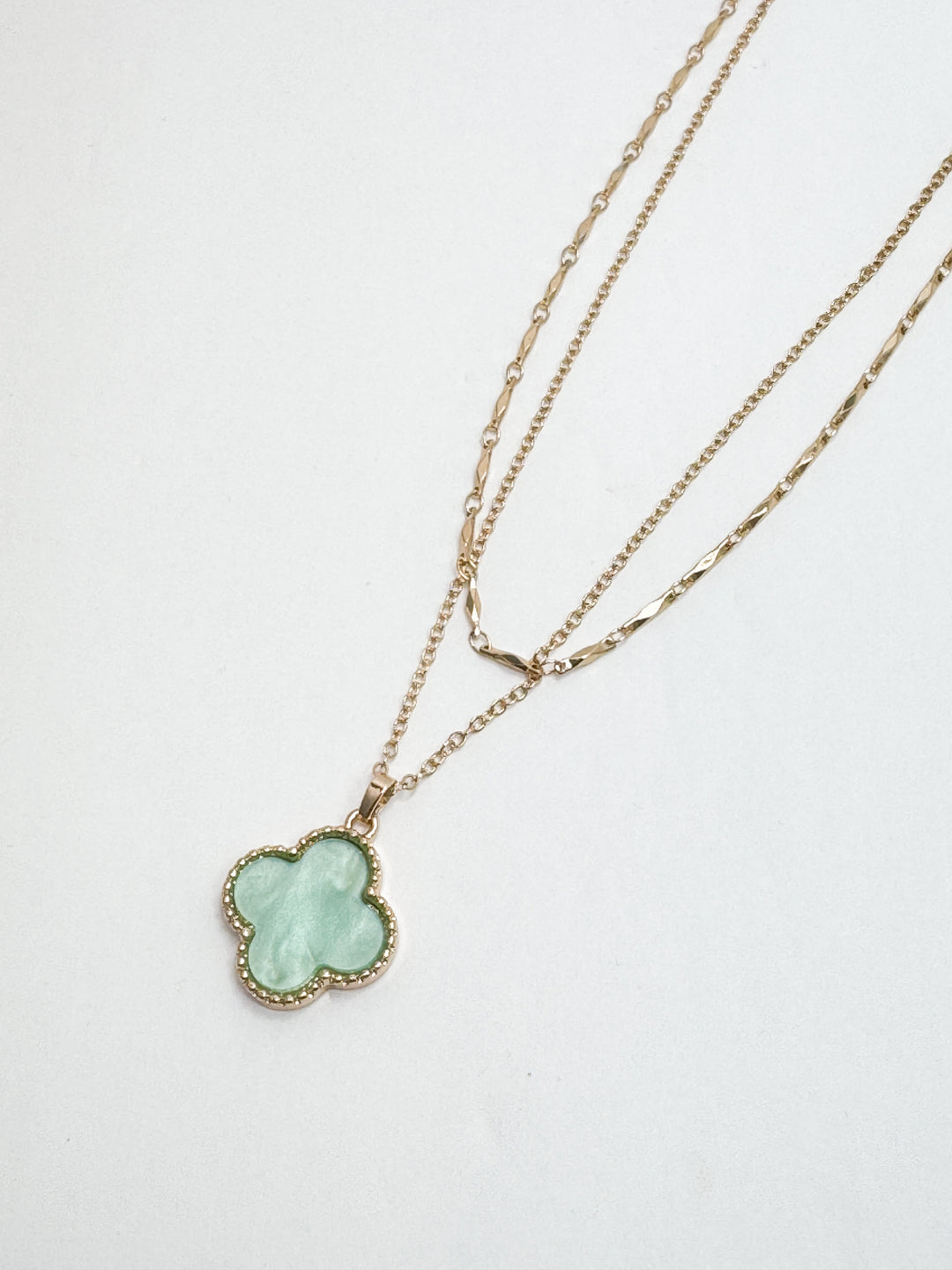 Necklace with a clover-shaped pendant on a white background