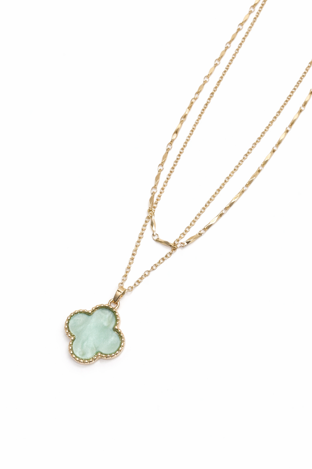 Gold necklace with a clover-shaped pendant on a white background
