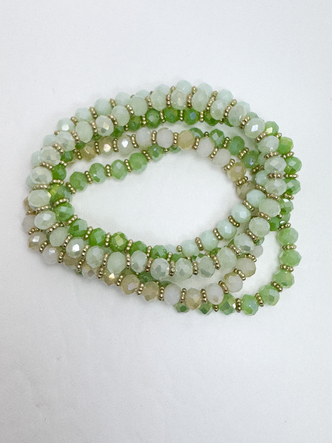 photo of green beaded bracelets in various shades on white background