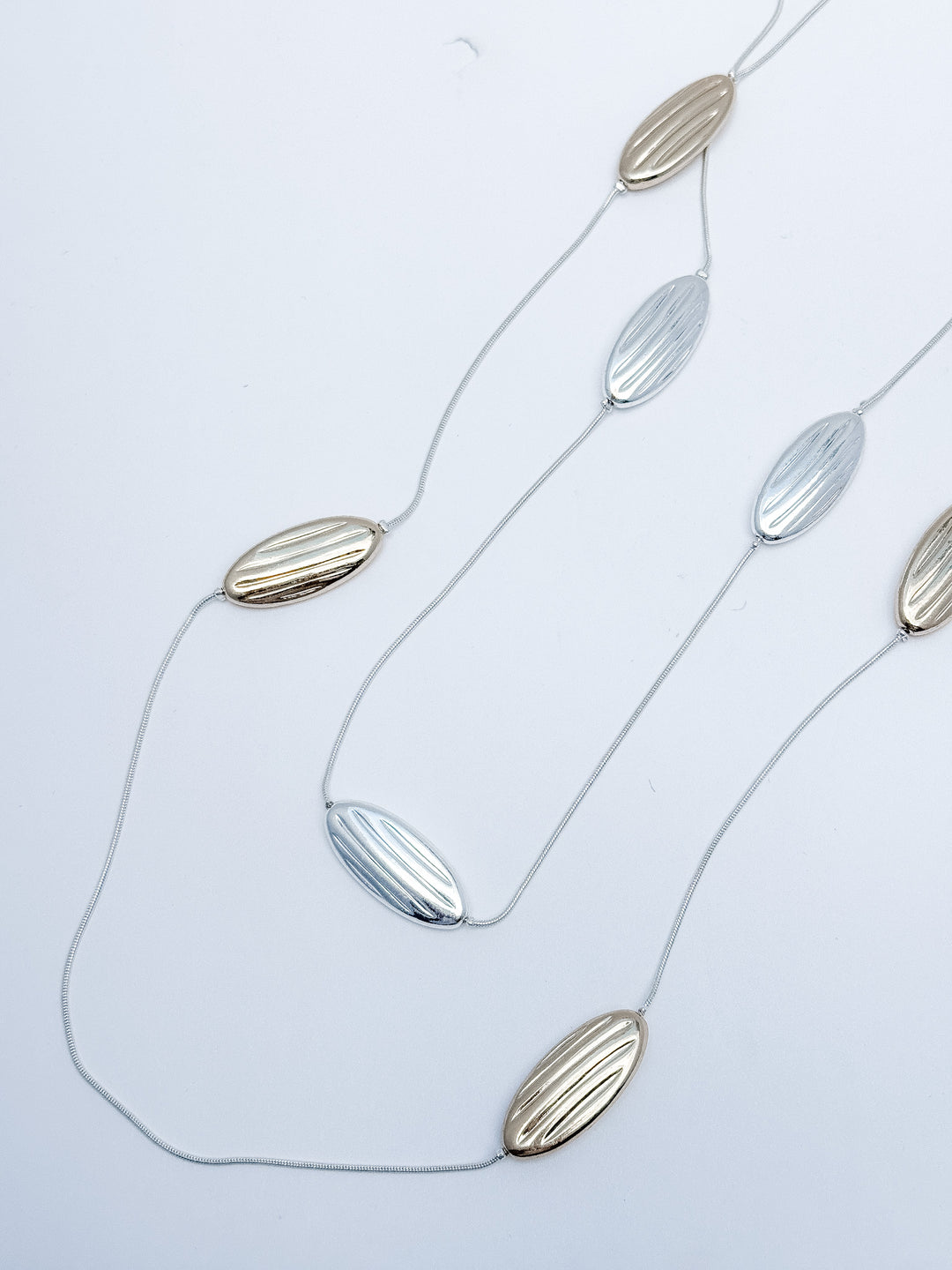 Necklace with leaf-shaped pendants on a light gray background