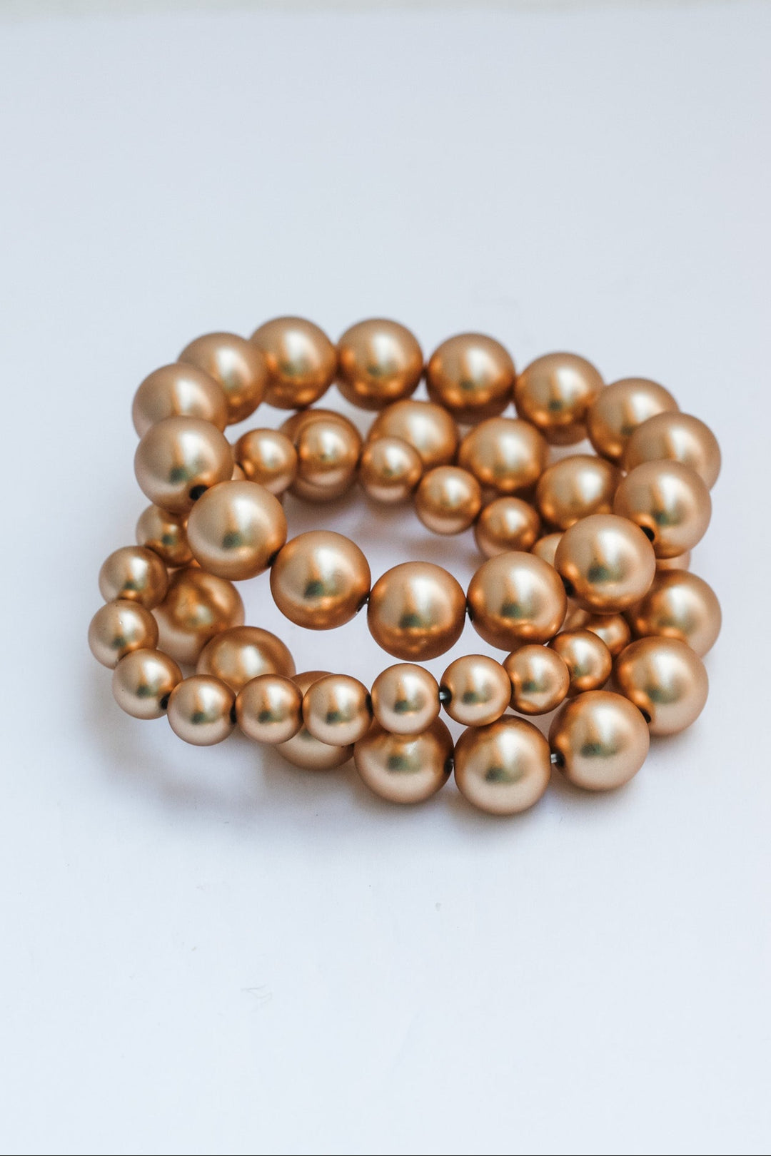 Gold pearl bracelet on a white background