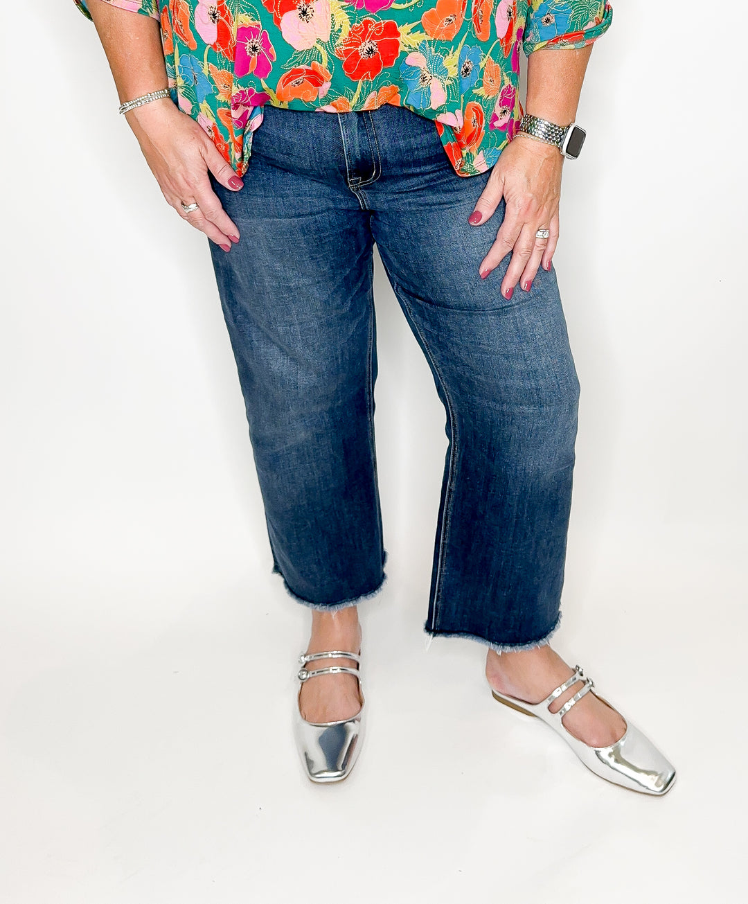 A person wearing mid-rise straight crop jeans with a vintage dark wash and white ankle boots.