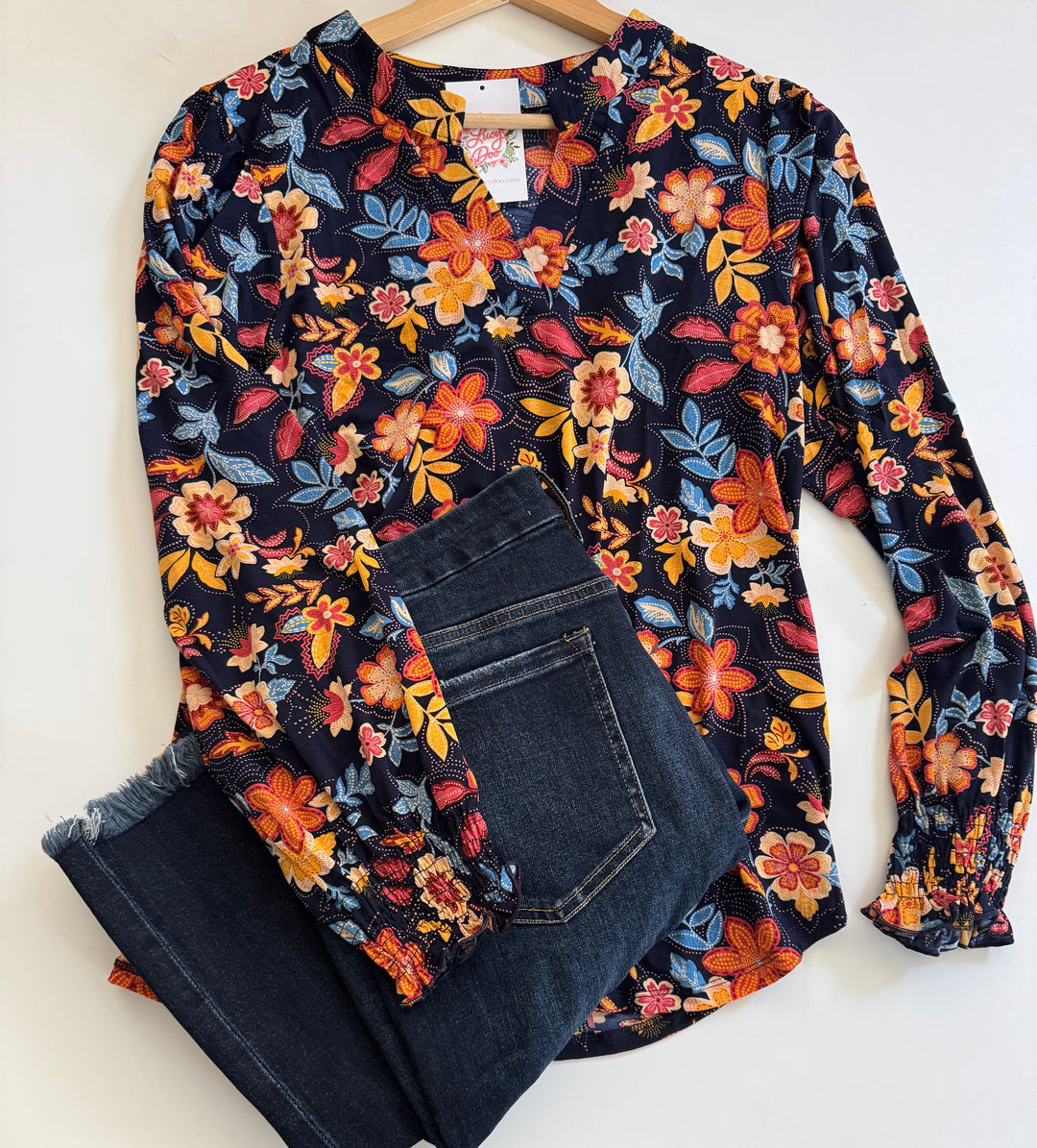 Floral-patterned long-sleeve shirt and jeans on a white background