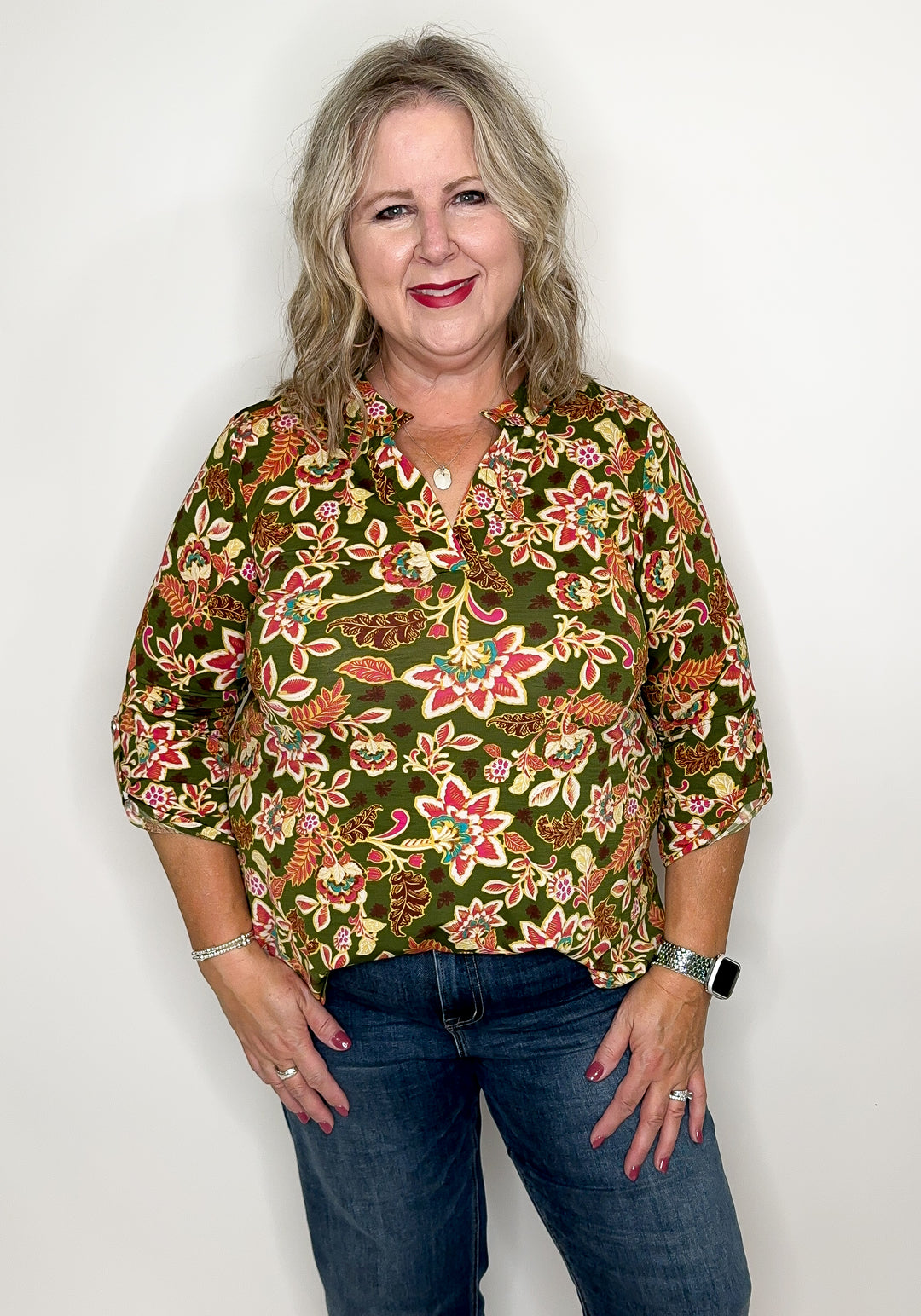 model wearing olive floral top in front of white background