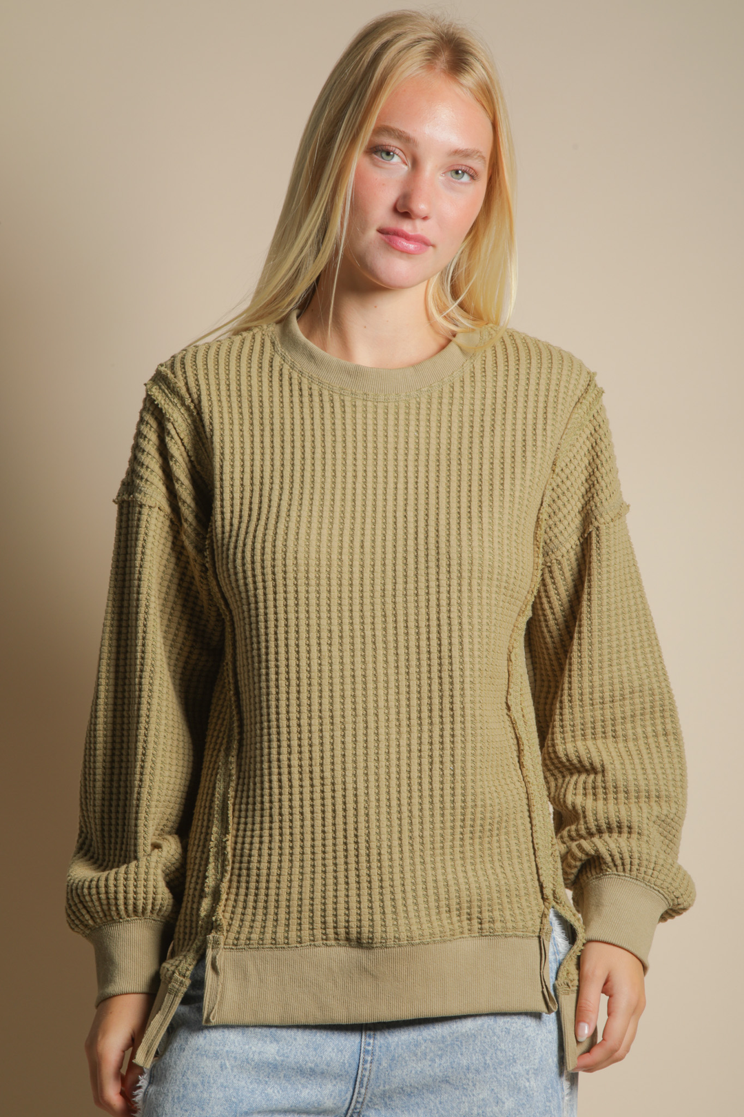 model wearing an olive waffle knit long sleeve top with jeans
