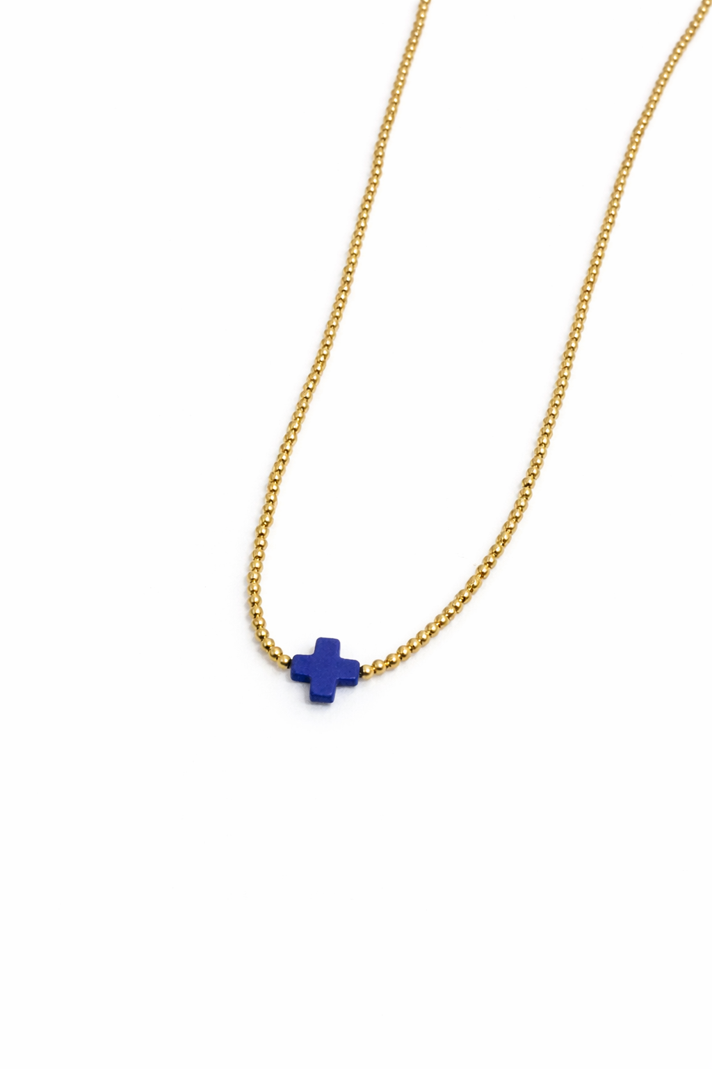 Gold necklace with a blue pendant on a white background