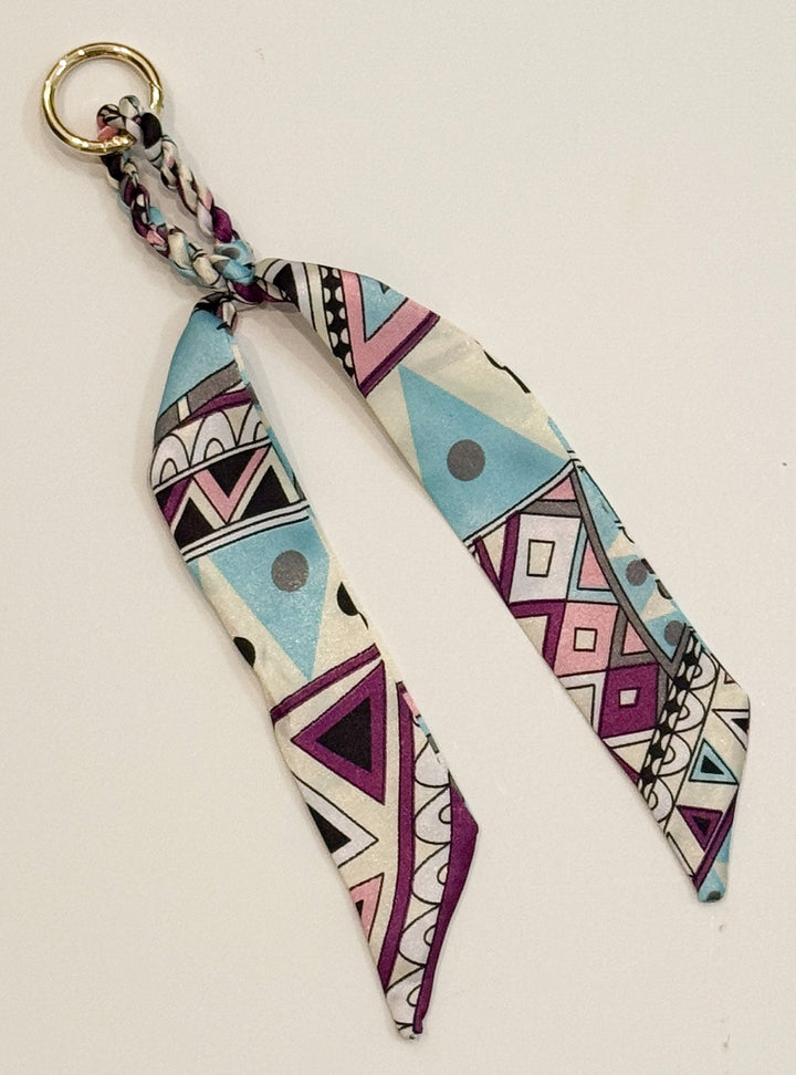 Geometric patterned purse charm on a white background