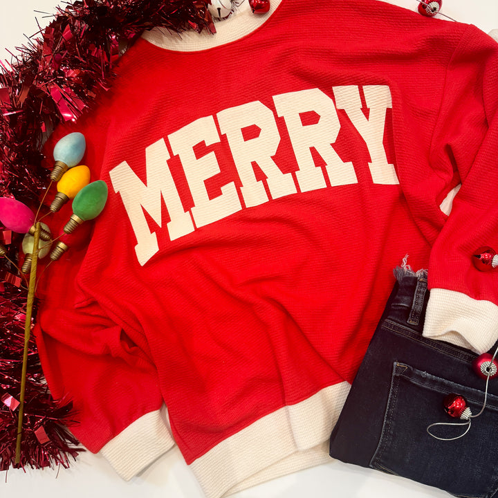 Red sweatshirt with 'MERRY' text, surrounded by Christmas decorations on a white background