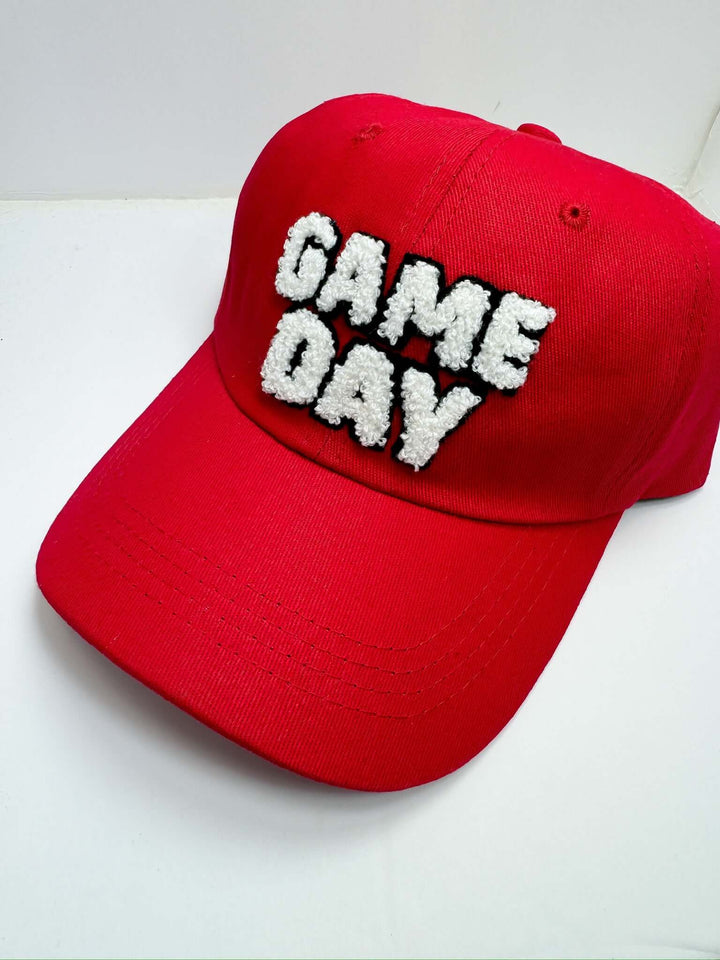 A red baseball cap with 'Game Day' text embroidered in white on the front.