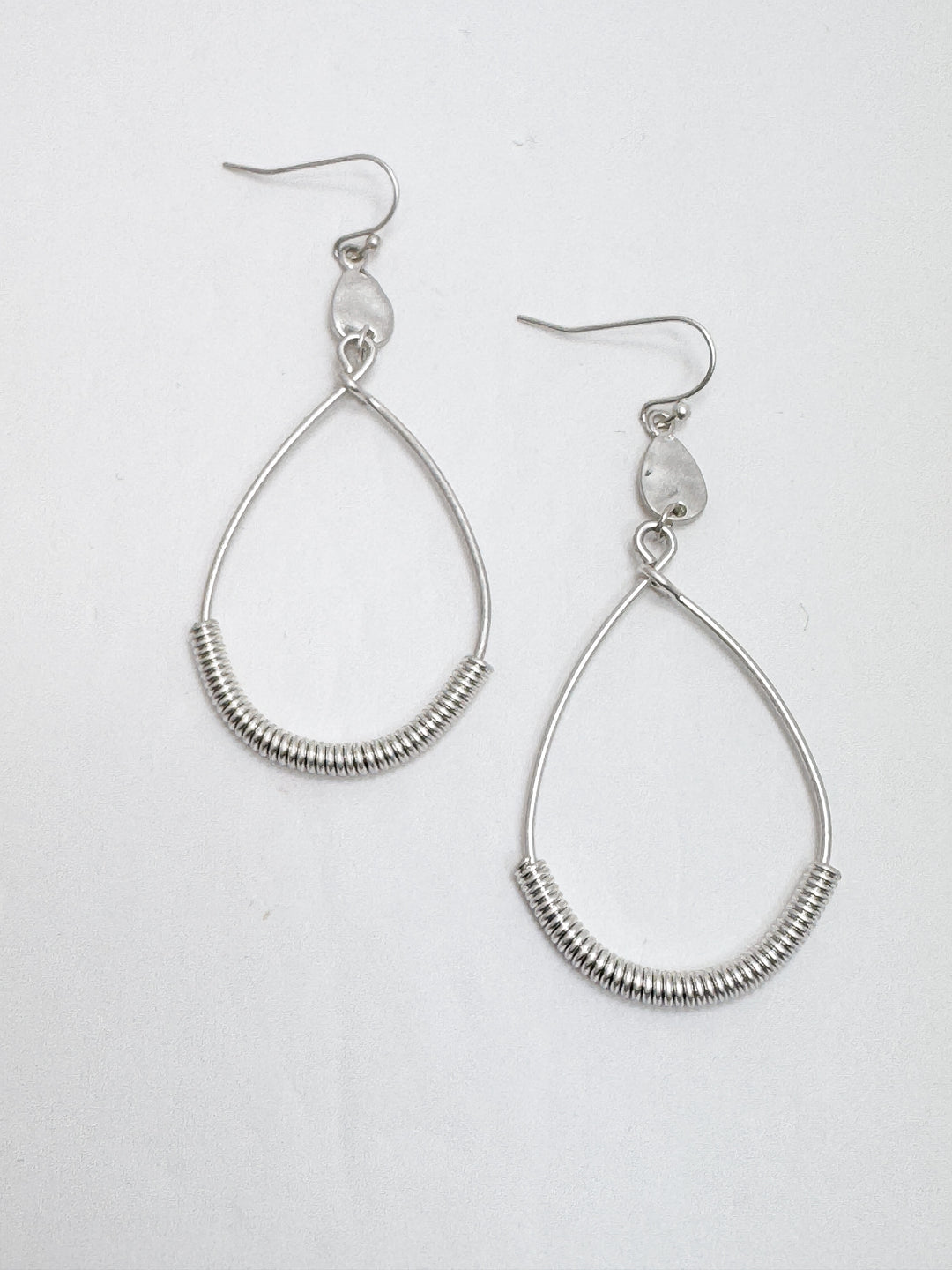 A pair of silver twisted wire drop earrings with small clear beads, displayed against a white background.