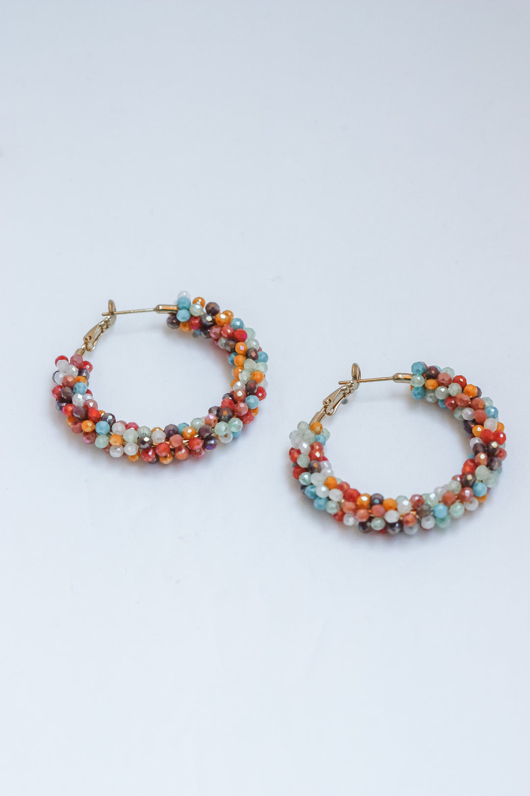 Pair of beaded hoop earrings on a light gray background