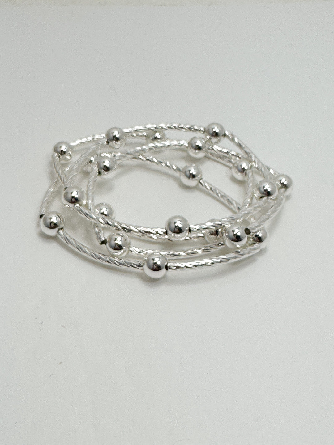 Silver beaded bracelet on a light gray background