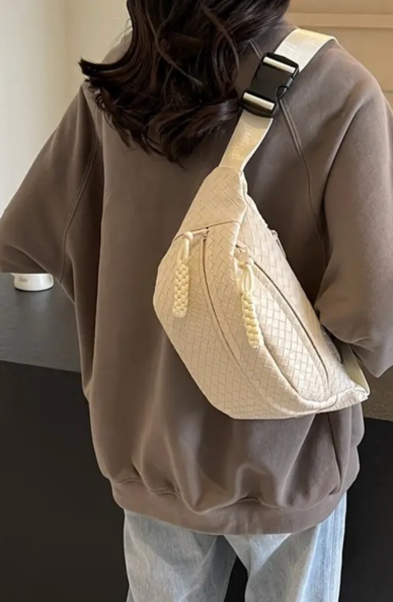 back view of woman wearing an off white woven crossbody